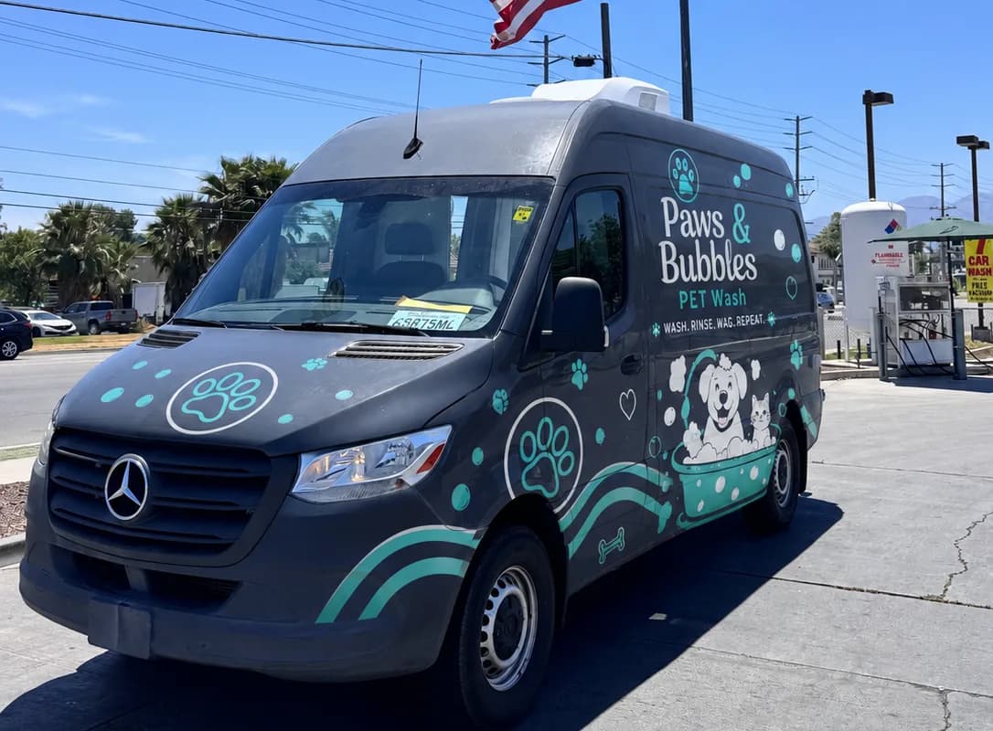 Spring Le Tour mobile grooming van shown with an example pet-wash brand wrap, front three-quarter view